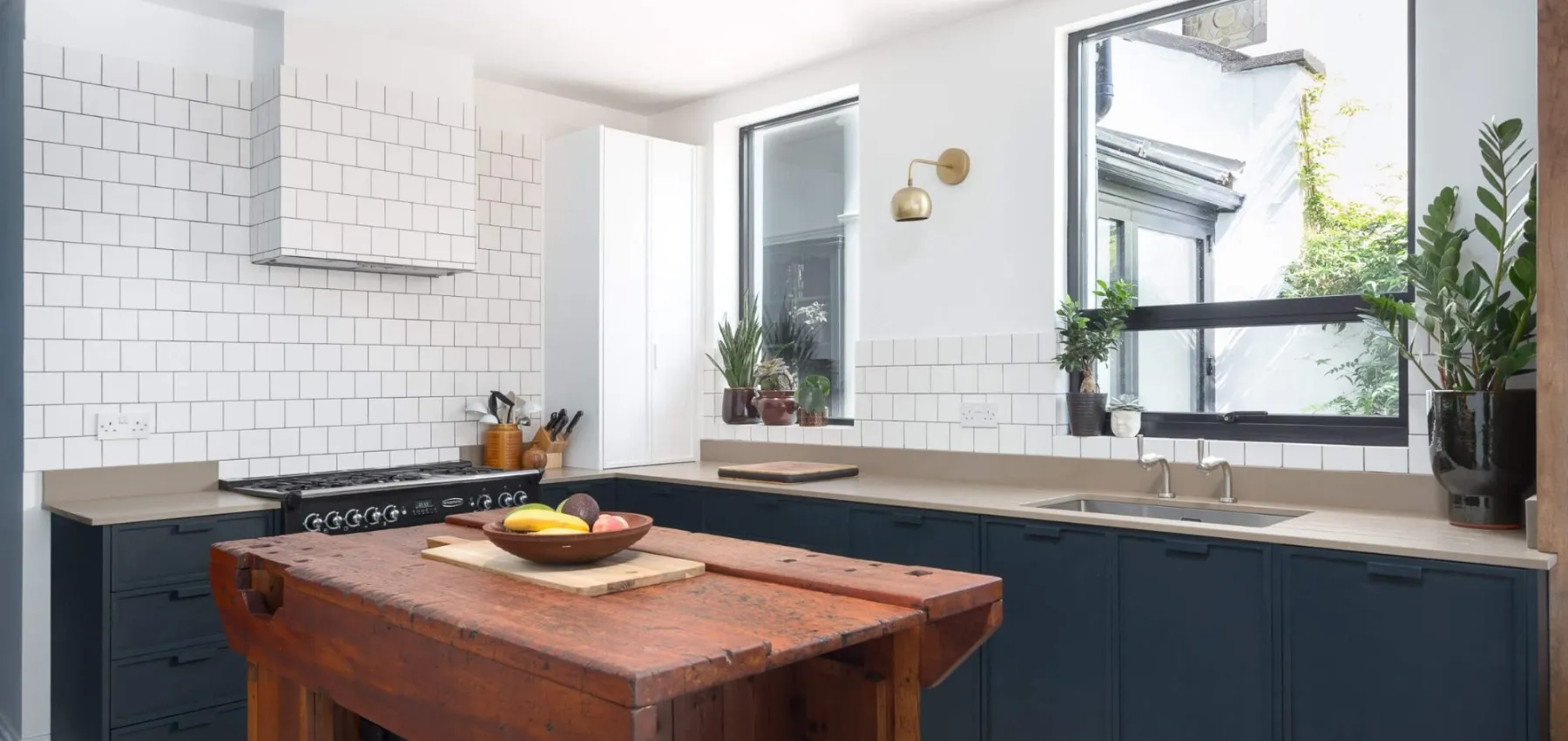 Navy shaker-style kitchen with a timber-topped island and white metro tiles
